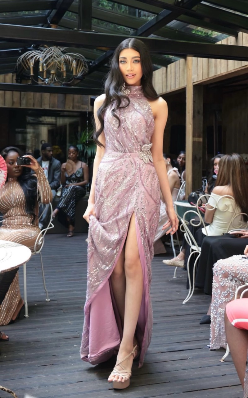 Angel Rae walking the runway in a lilac embellished halterneck gown.